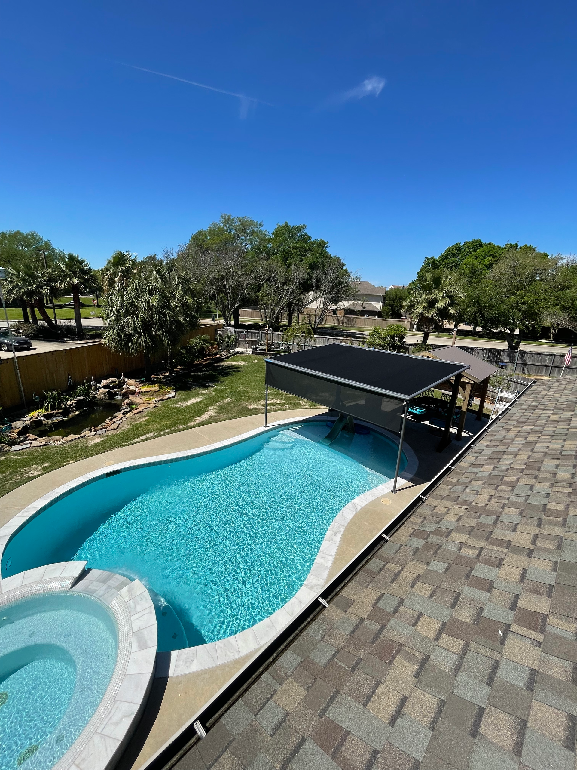 A large swimming pool with a hot tub next to it