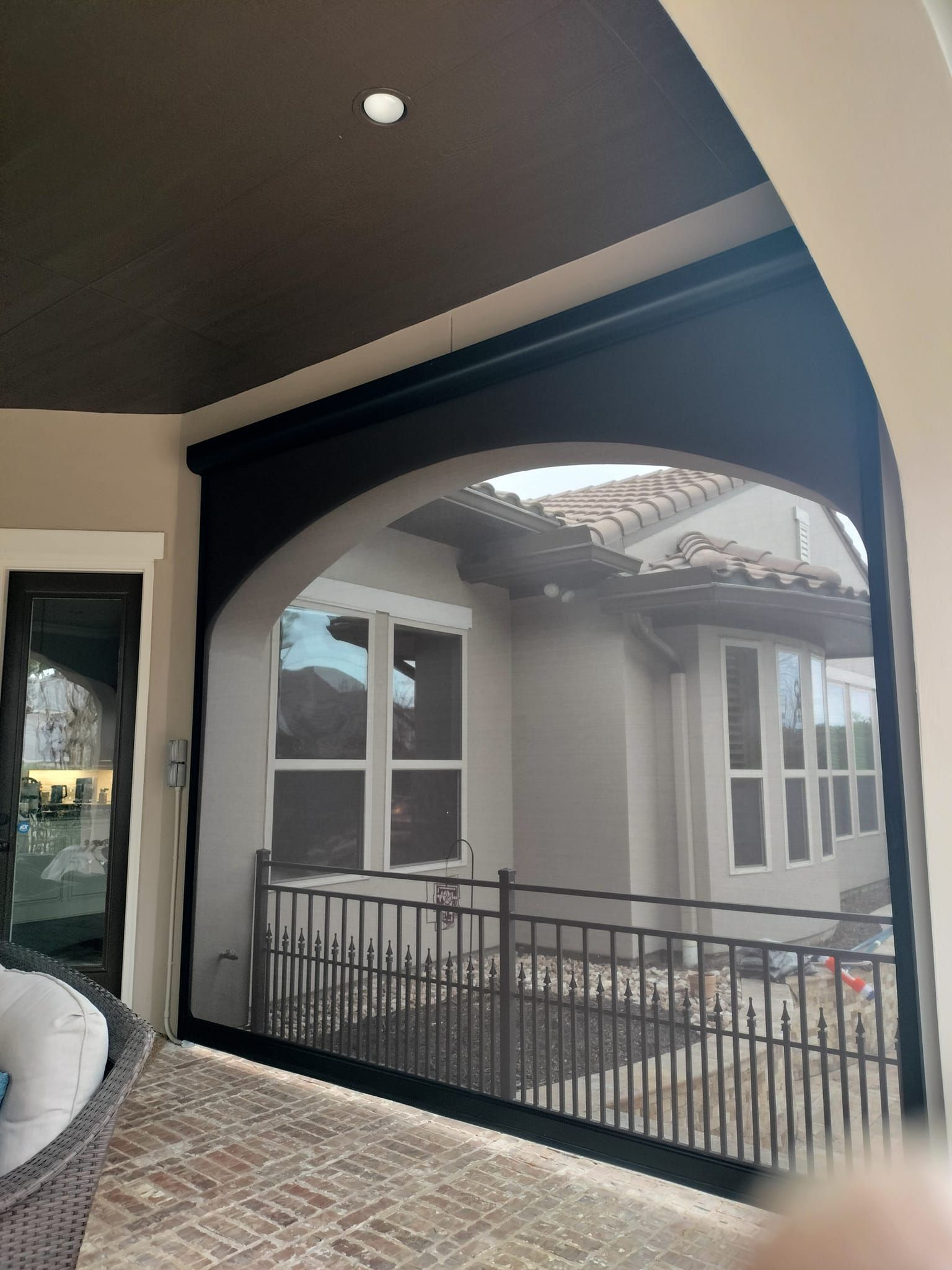 A screened in porch with a view of a house