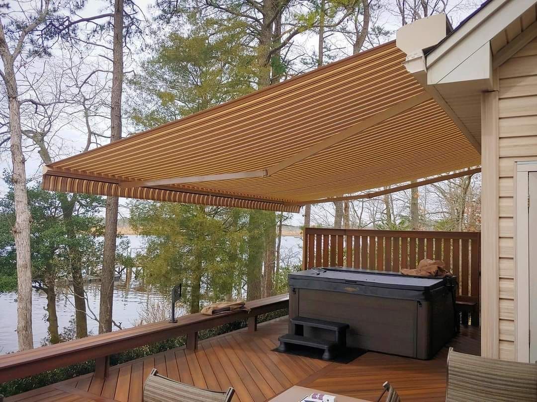 A hot tub on a deck with a motorized awning over it