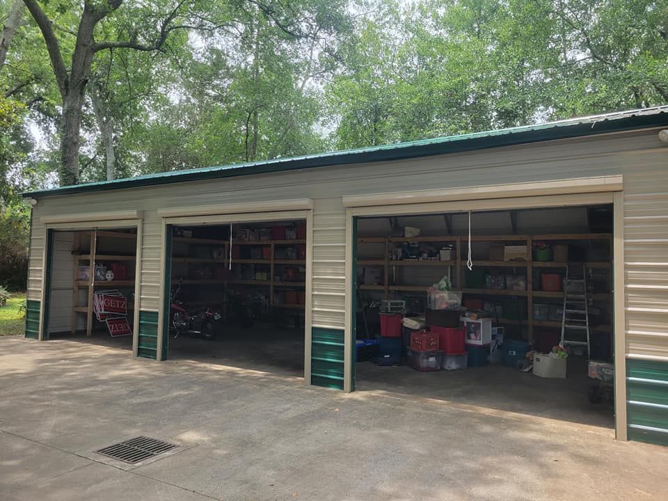 A large garage with three garage doors filled with lots of items.