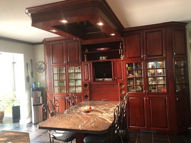 Une cuisine avec armoires en bois et comptoir en granite