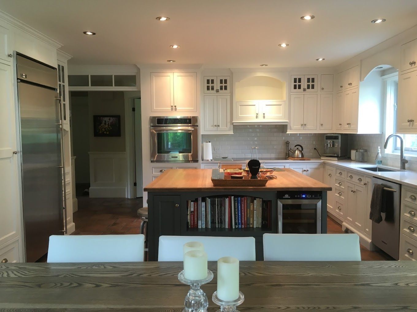 Une cuisine avec des armoires blanches et des appareils électroménagers en acier inoxydable