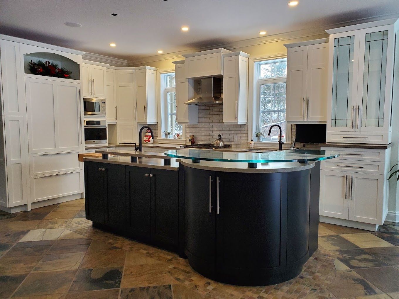 Une cuisine avec un grand îlot au milieu et des armoires blanches.