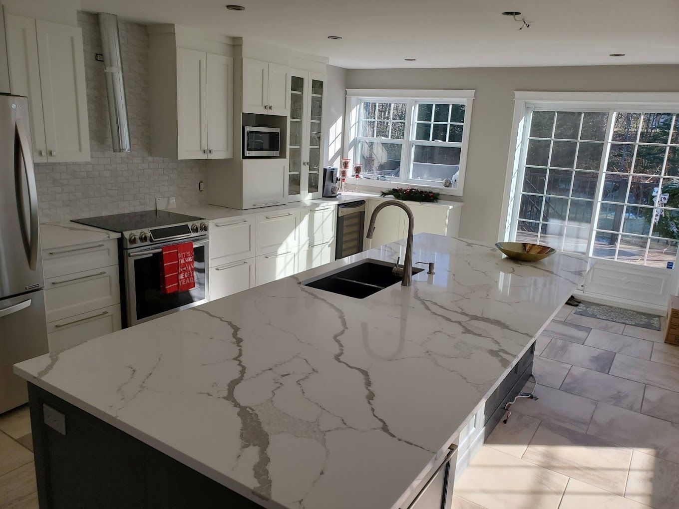 Une cuisine avec un grand îlot , un évier , une cuisinière et un réfrigérateur.