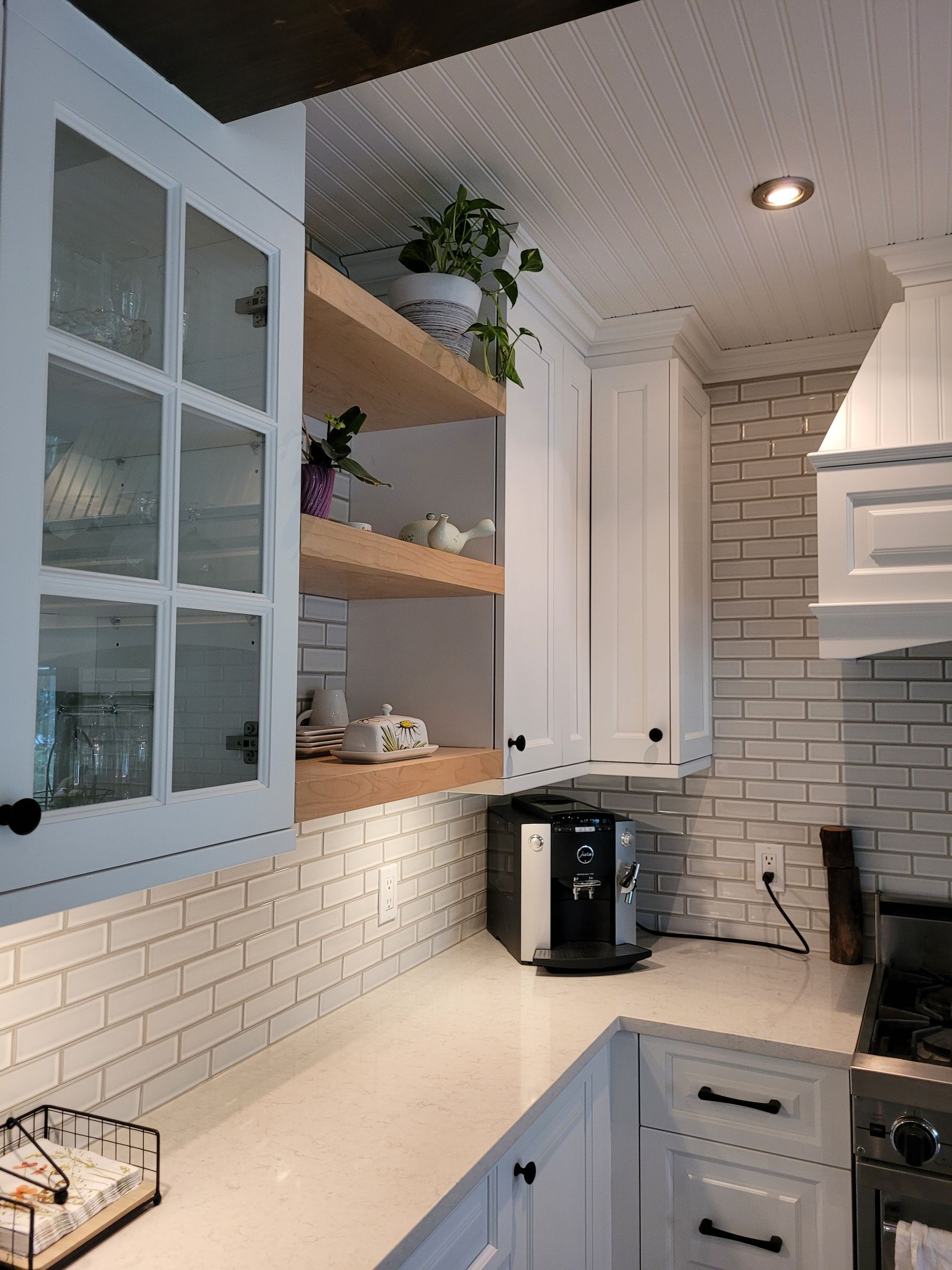 Une cuisine avec armoires blanches et une cafetière sur le comptoir