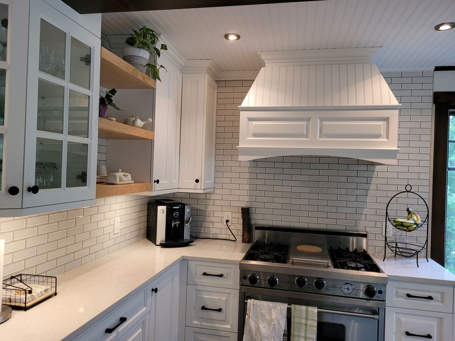 Une cuisine avec des armoires blanches et un four sur cuisinière