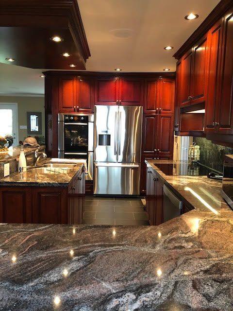 Une cuisine avec appareils électroménagers en acier inoxydable et comptoirs en granit