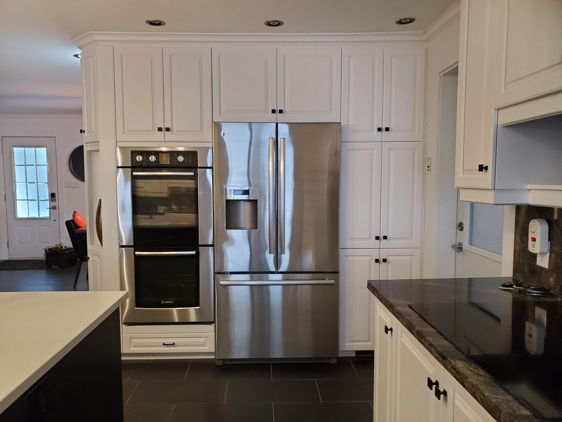 Une cuisine avec des appareils électroménagers en acier inoxydable et des armoires blanches