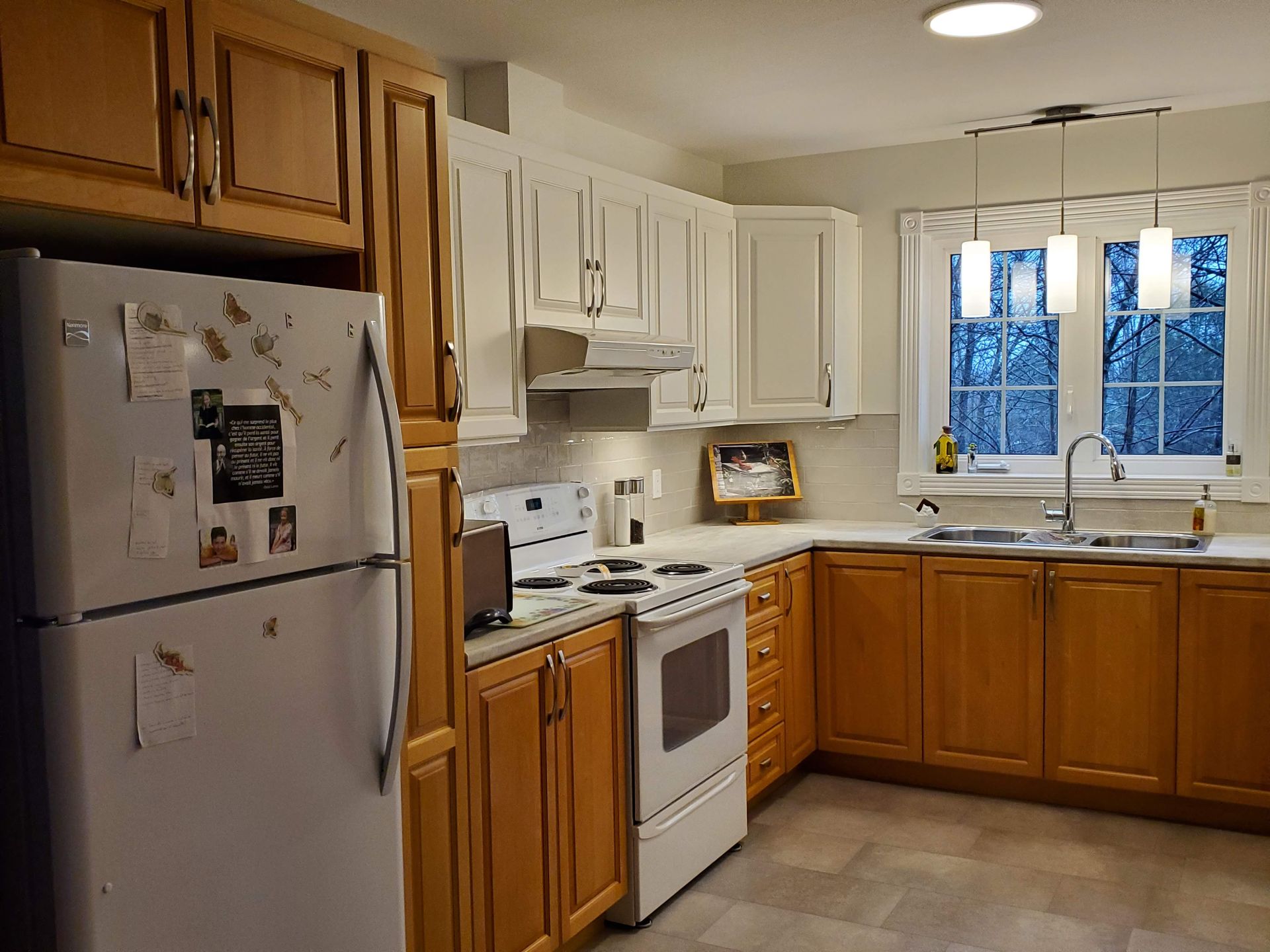 Une cuisine avec des armoires en bois et un réfrigérateur blanc