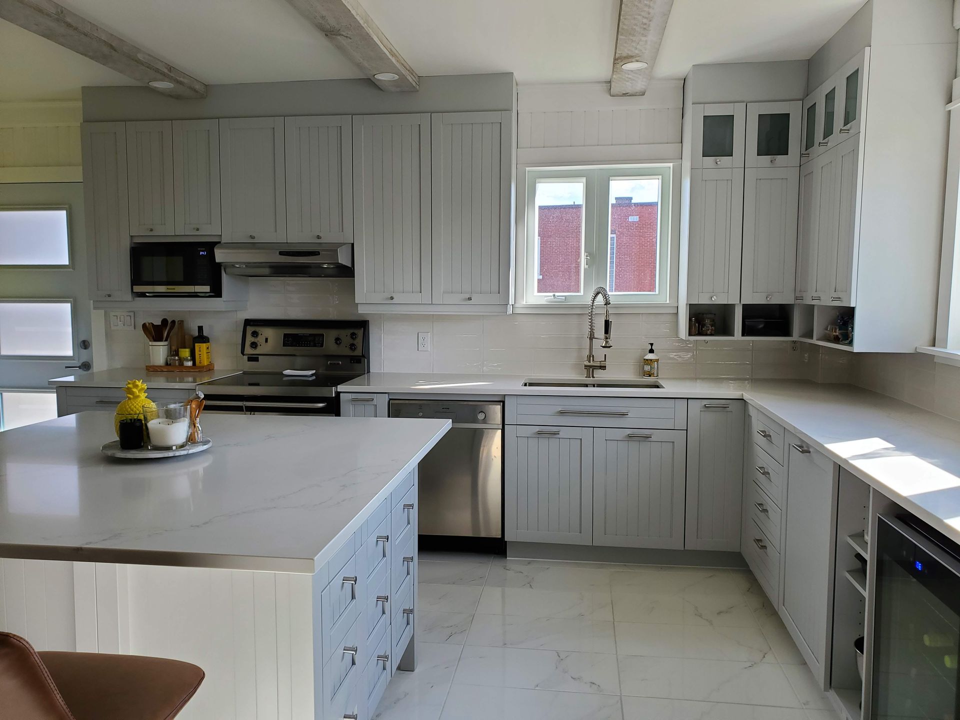 Une cuisine avec des armoires blanches et des appareils électroménagers en acier inoxydable