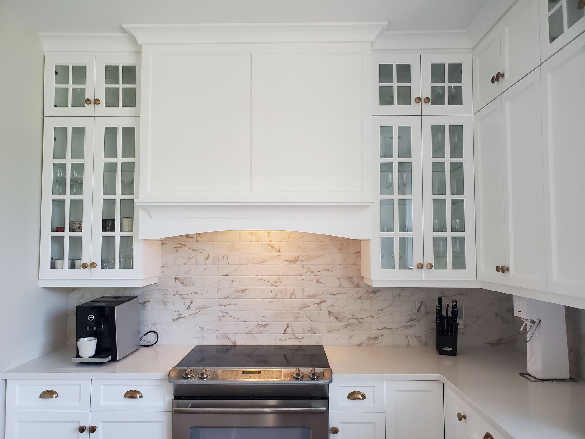 Une cuisine avec des armoires blanches et un four sur cuisinière