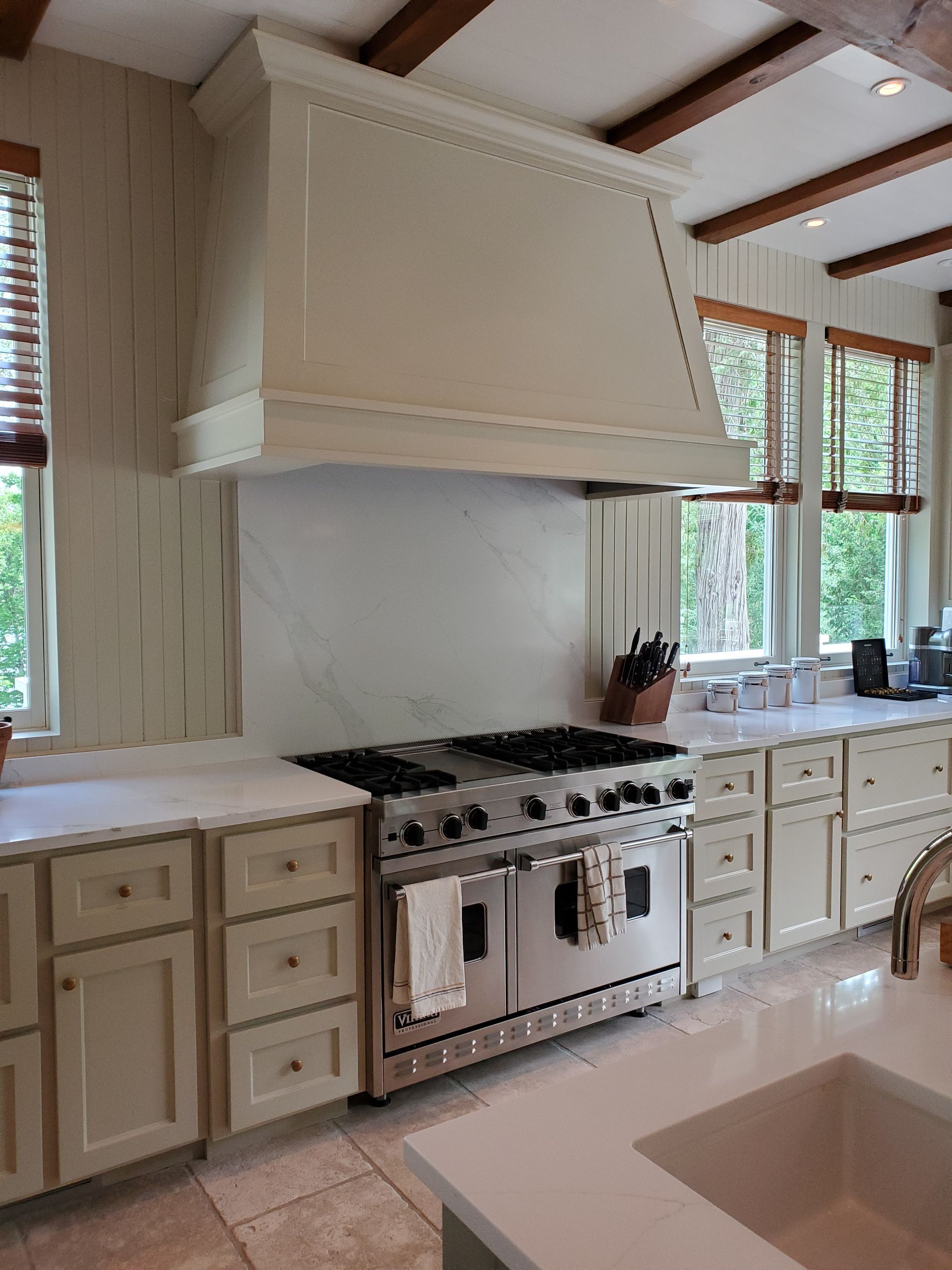 Une cuisine avec des appareils électroménagers en acier inoxydable et des armoires blanches