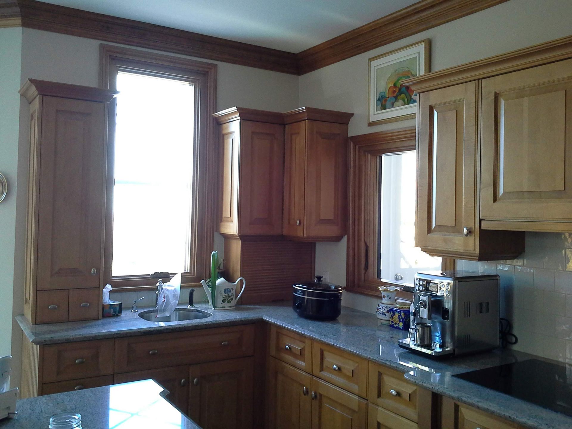 Une cuisine avec armoires en bois et comptoirs en granit