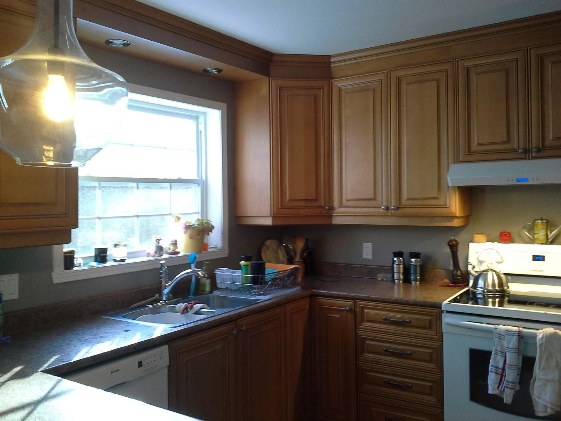 Une cuisine avec armoires en bois et cuisinière et évier