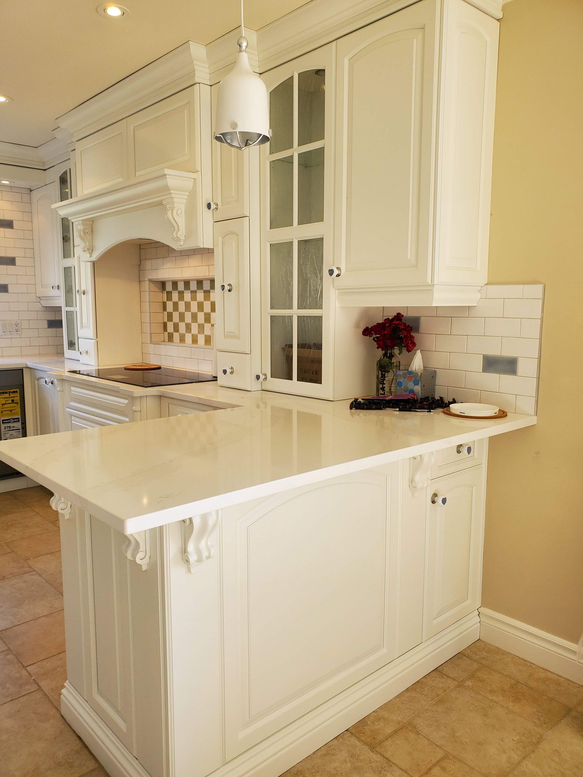 Une cuisine avec armoires blanches et un grand îlot