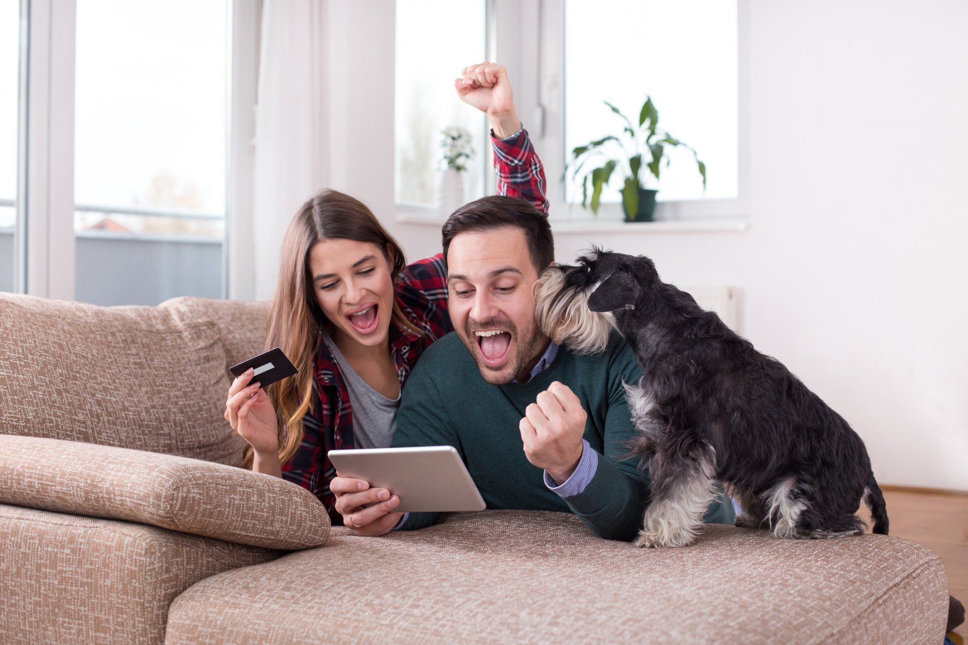 Excited Young Couple With Tablet and Coupon Card — Studio City, CA — Rusty’s Discount Pet Center