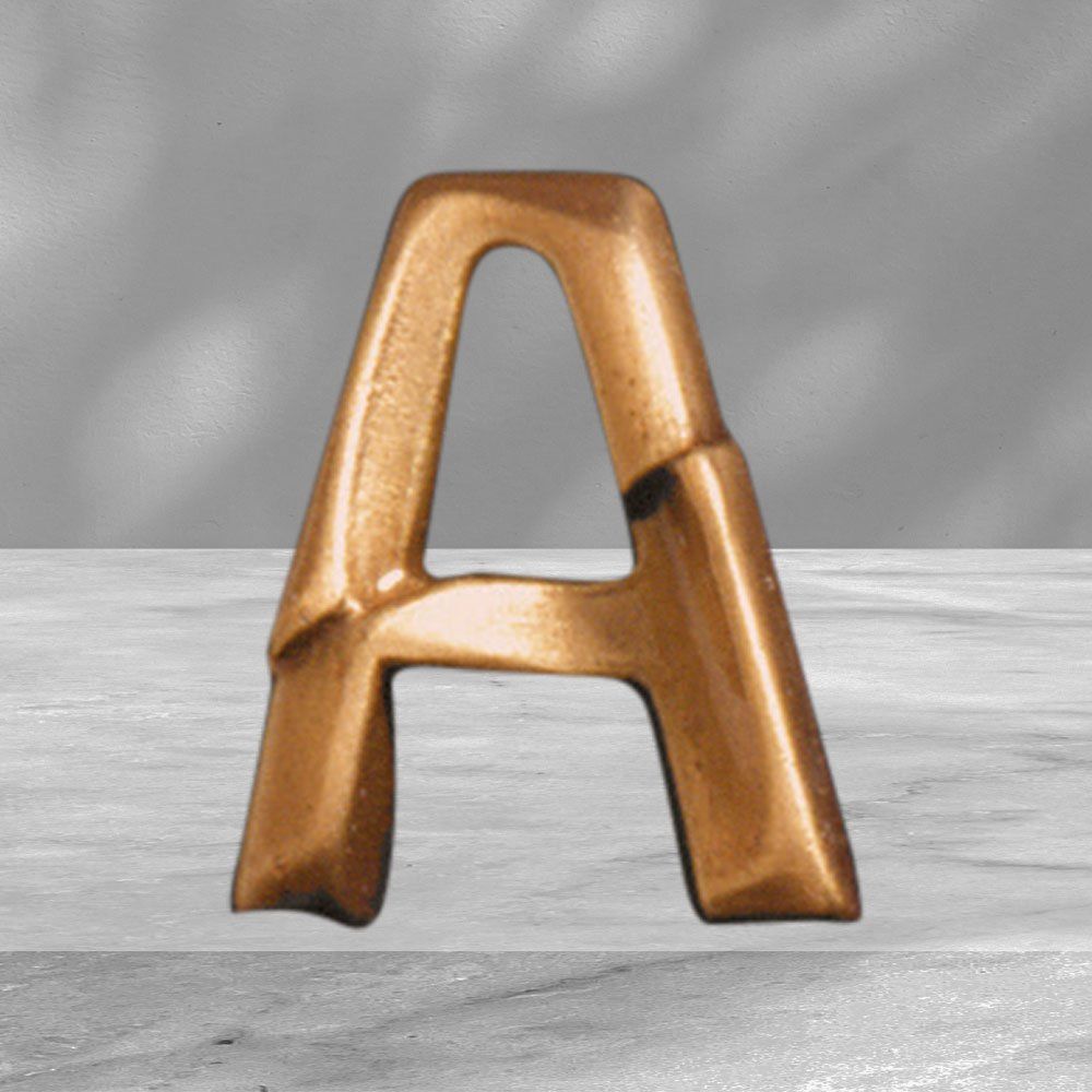 lettera A in bronzo su sfondo grigio