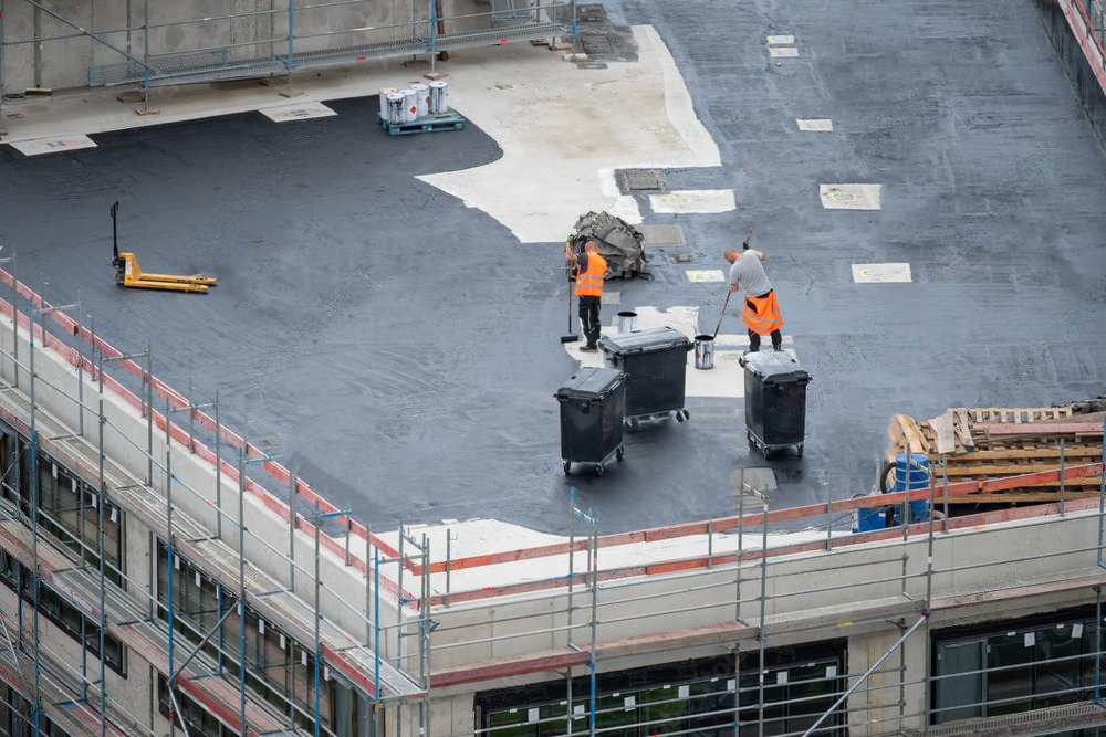 a group of construction workers are working on the roof of a building .