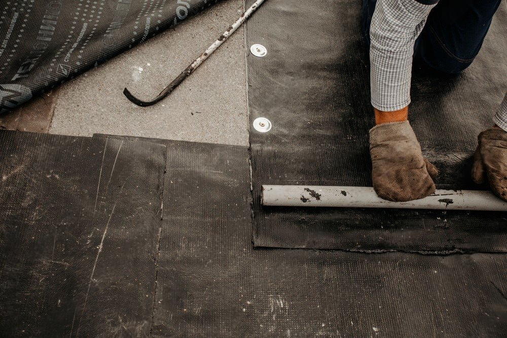 a person is working on a roof with a pipe .