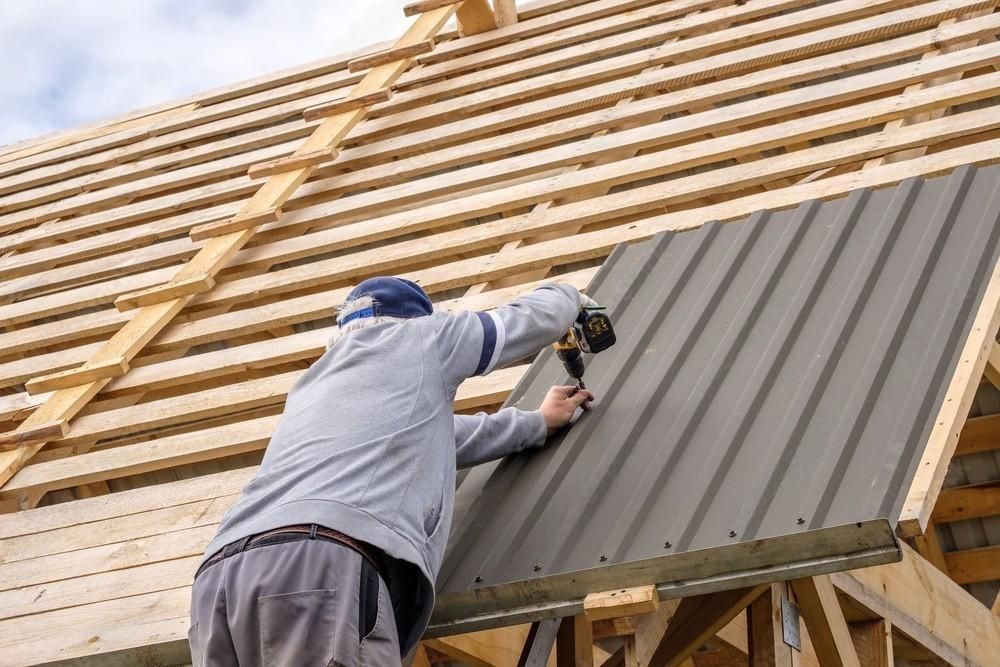 a man is installing a metal roof on a house .