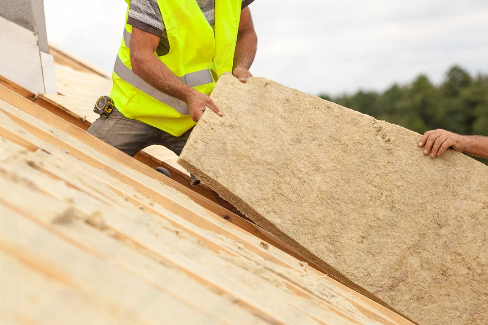 a man is carrying a large piece of wood on top of a wooden roof .