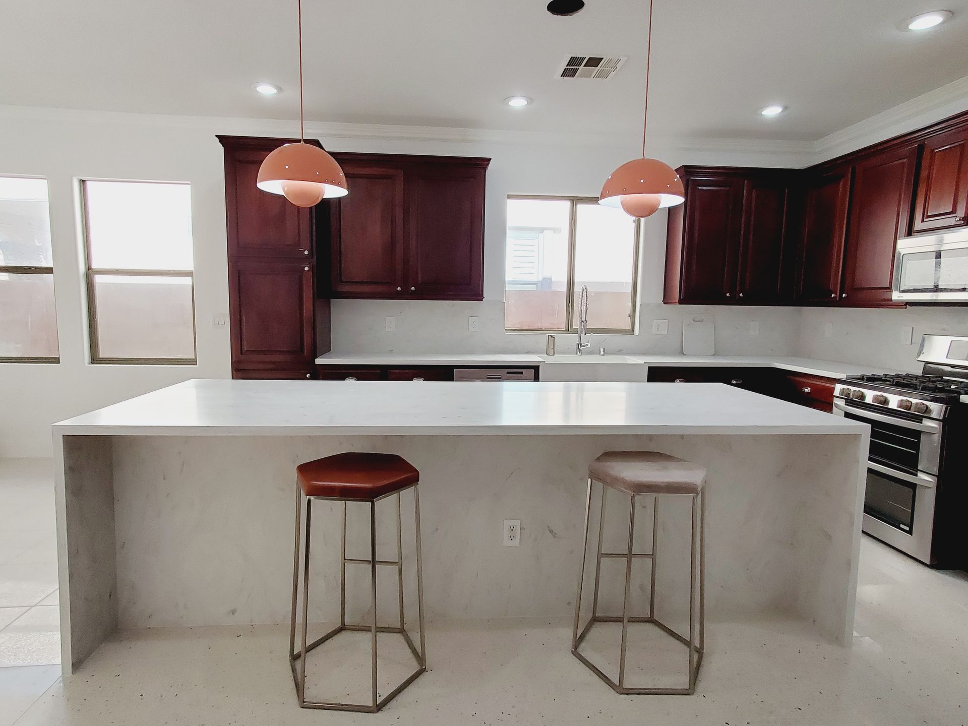 A kitchen with blue cabinets , white counter tops, and a large island.