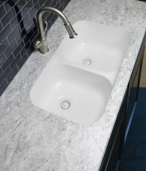 A kitchen sink with two bowls and a faucet