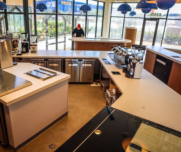 A man in a red hat sits at a counter in a kitchen