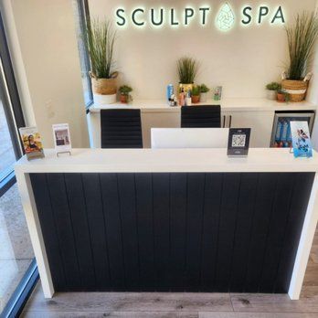 A reception desk in a spa with a sign that says sculpt spa
