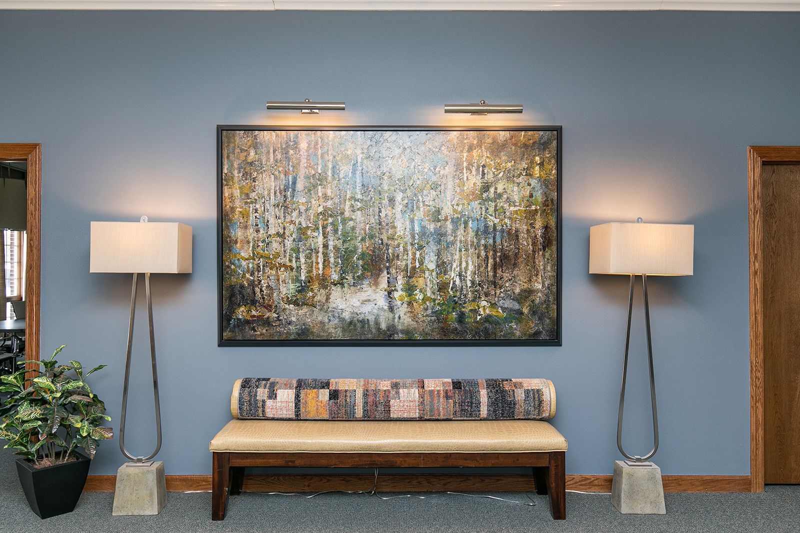 A painting hangs above a bench in a hallway