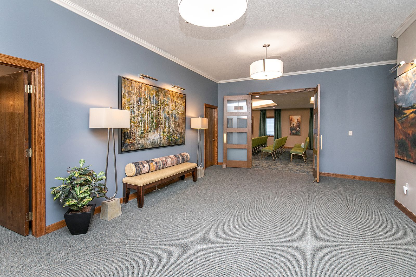 A hallway with a bench and a painting on the wall.