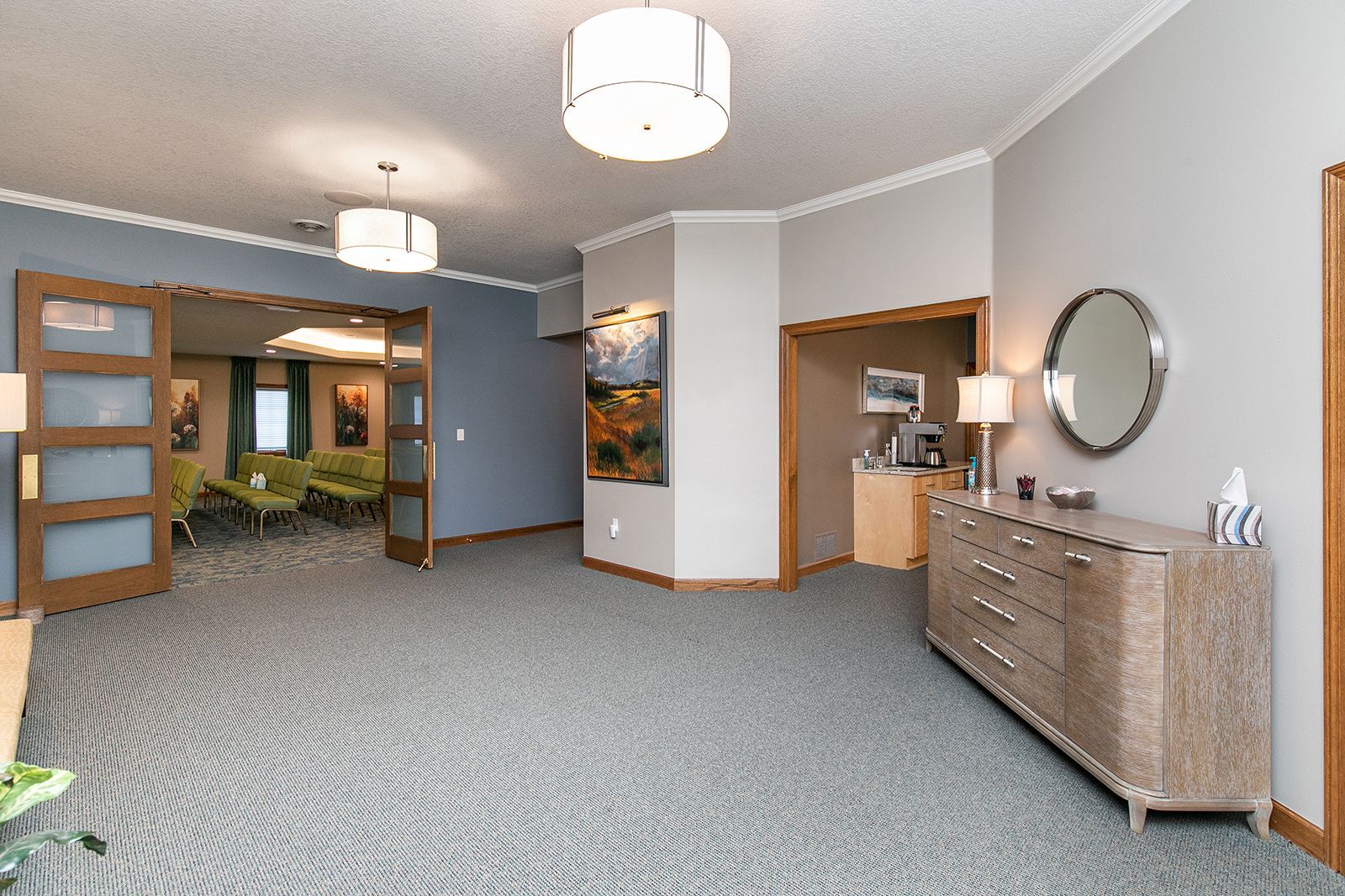 A large room with a dresser and a mirror in it.