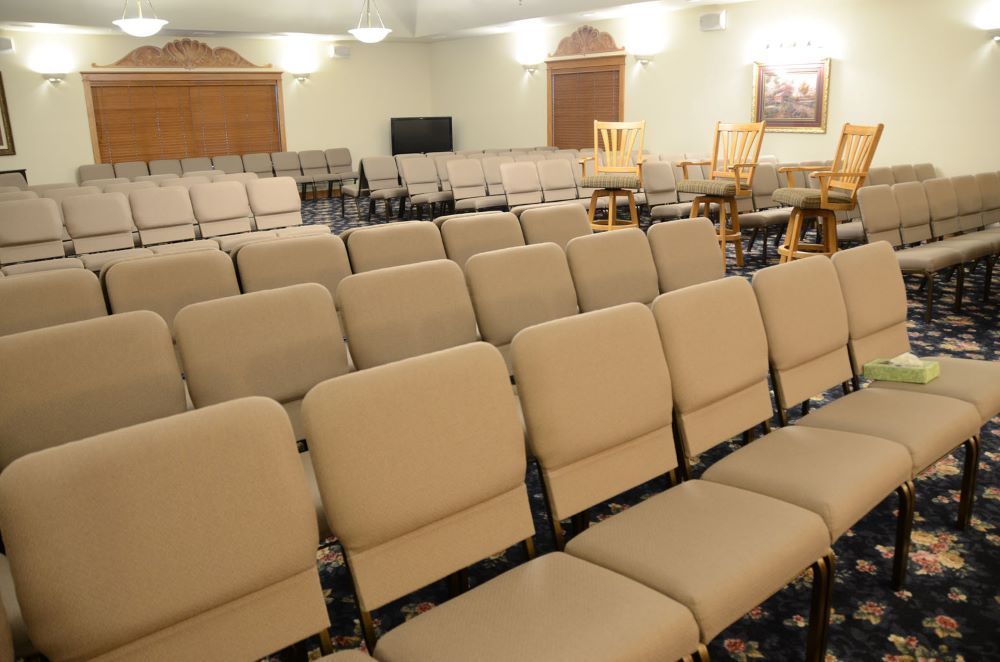 Rows of chairs are lined up in a large room.