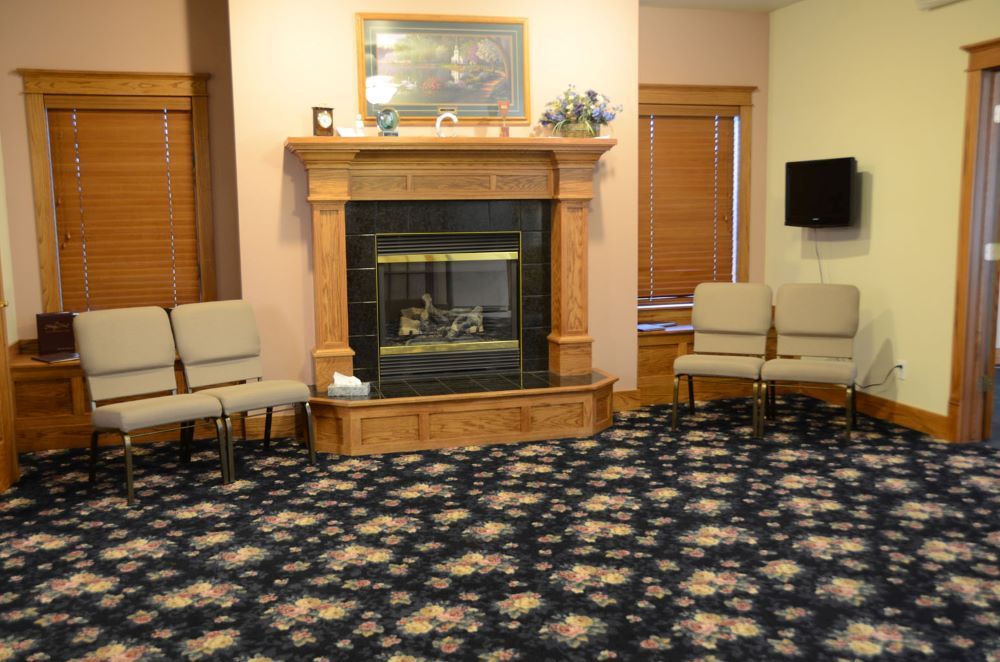 A living room with a fireplace , chairs and a television.