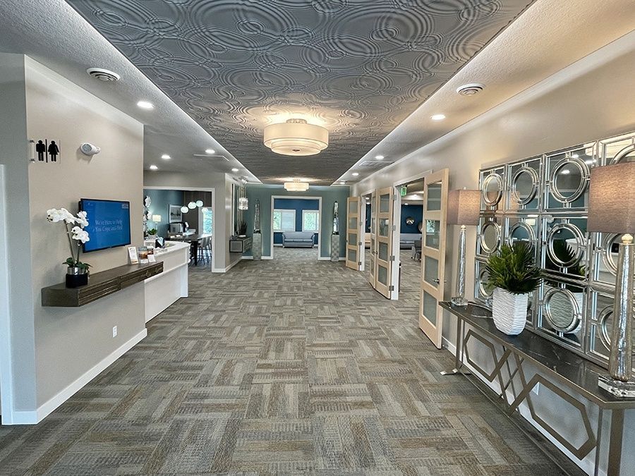 A long hallway with a carpeted floor and a television on the wall.