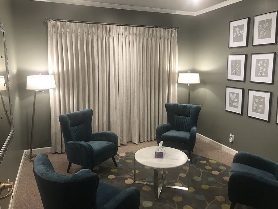 A living room with three chairs and a table.