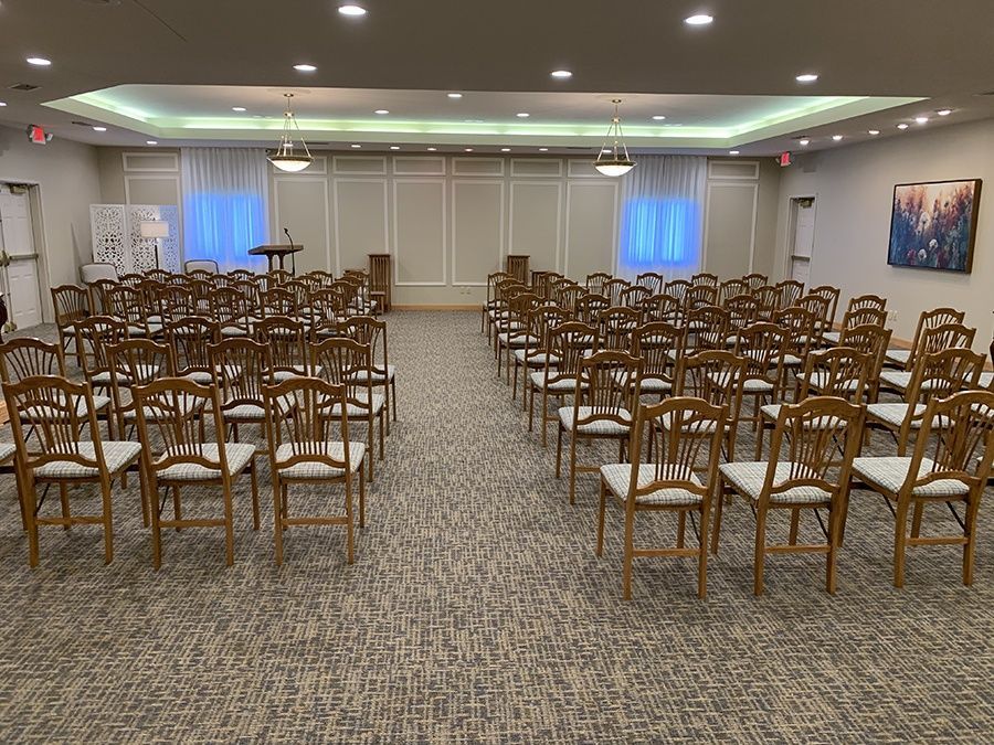 A large room filled with rows of chairs and a podium.