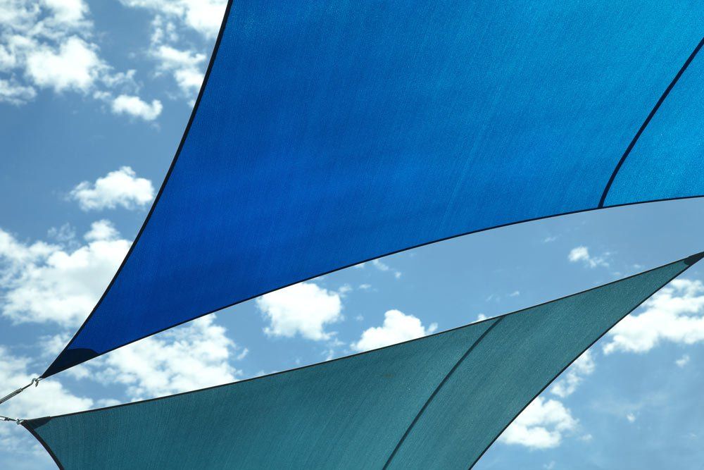 blue and aqua shade sails above with blue sky behind