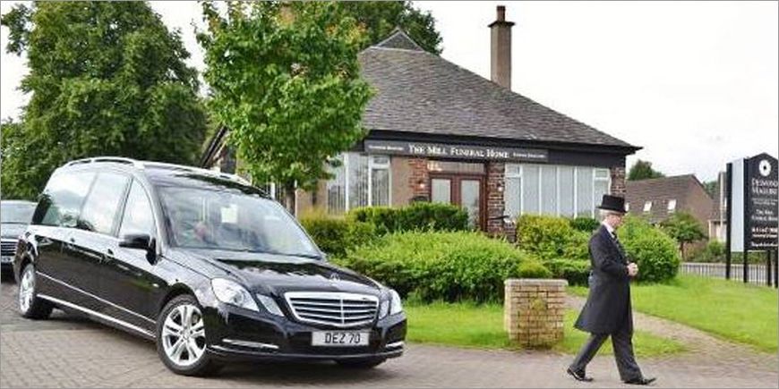 A funeral cortege being paced past the Mill Funeral Home