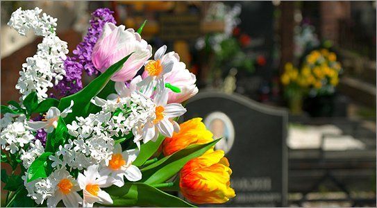 Brightly coloured flower arrangement, with headstones in the background