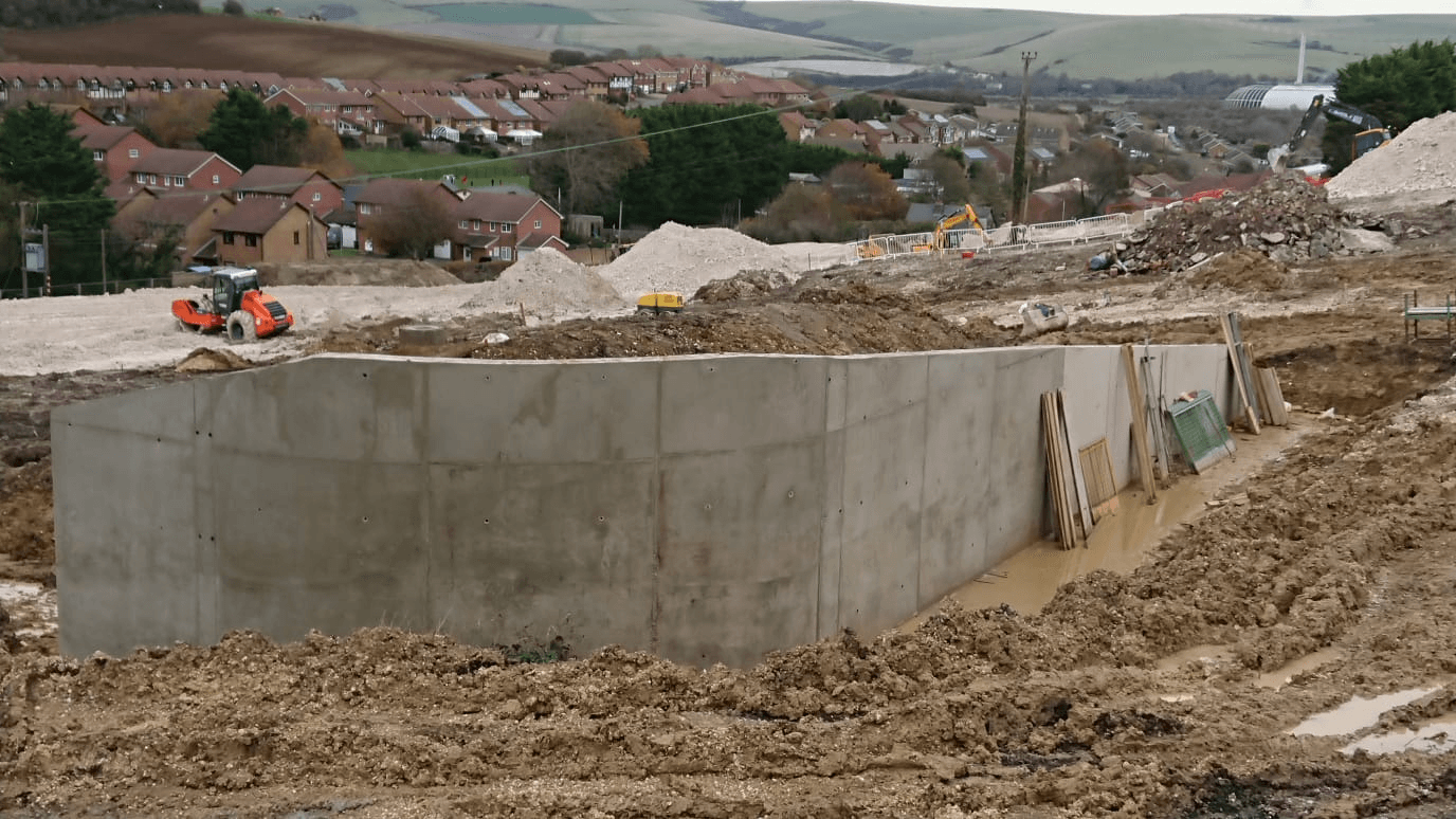 Concrete walls to form a bellmouth for a drop-down road to a new housing estate in East Sussex