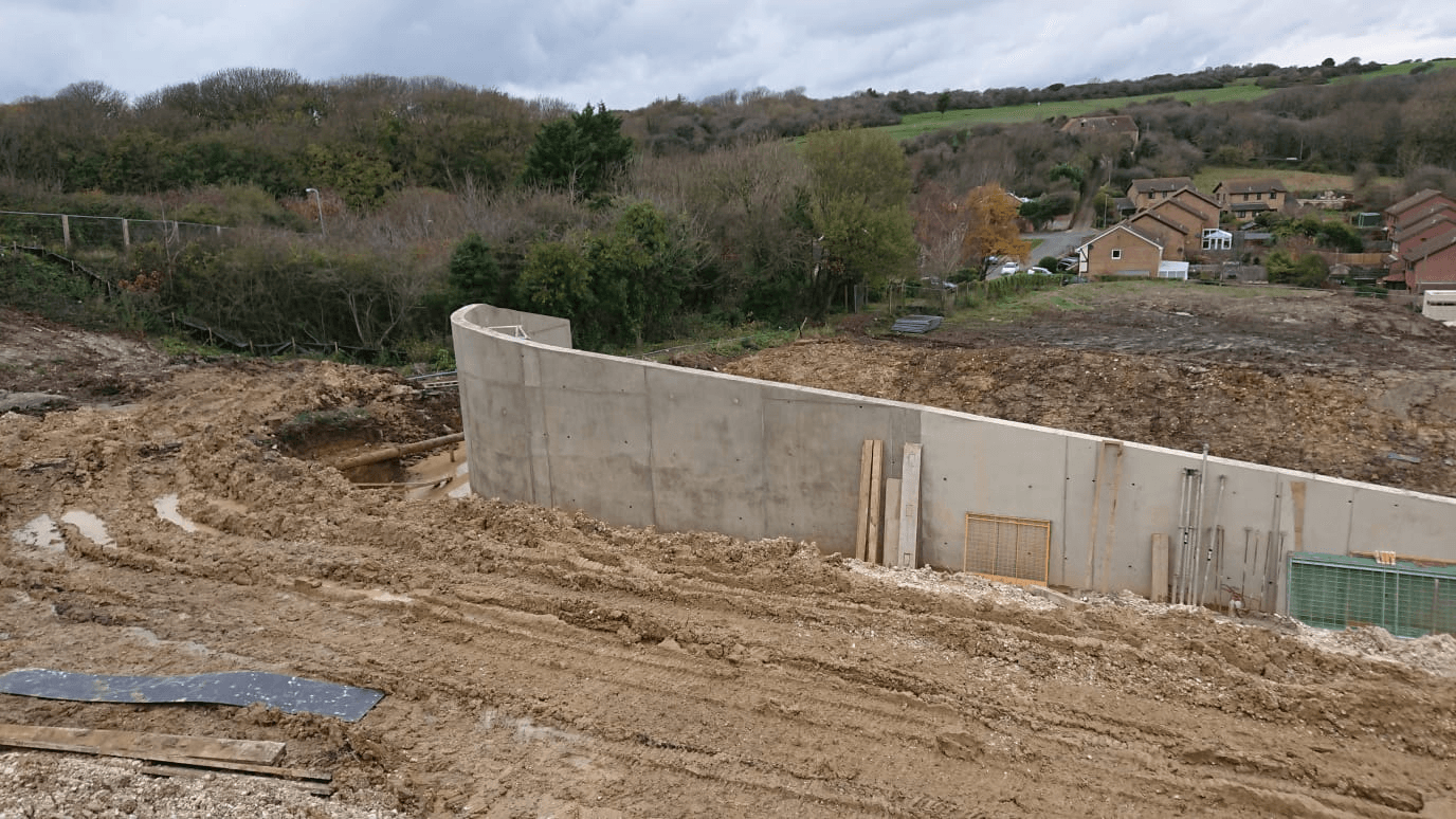 Concrete walls to form a bellmouth for a drop-down road to a new housing estate in East Sussex