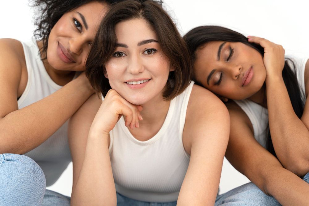 Three women are sitting next to each other on the floor.