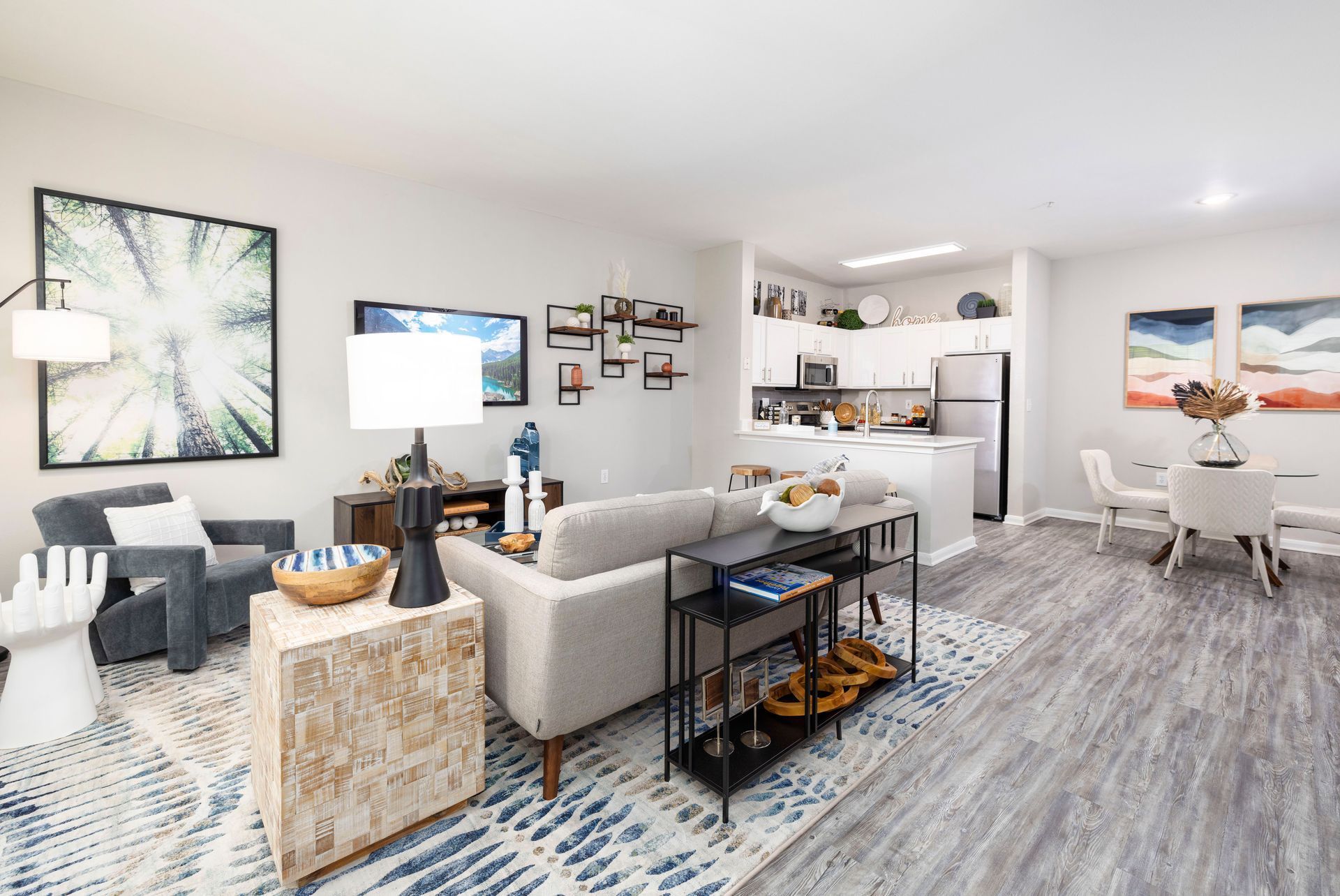 A room with a couch , chairs , a table and a rug.