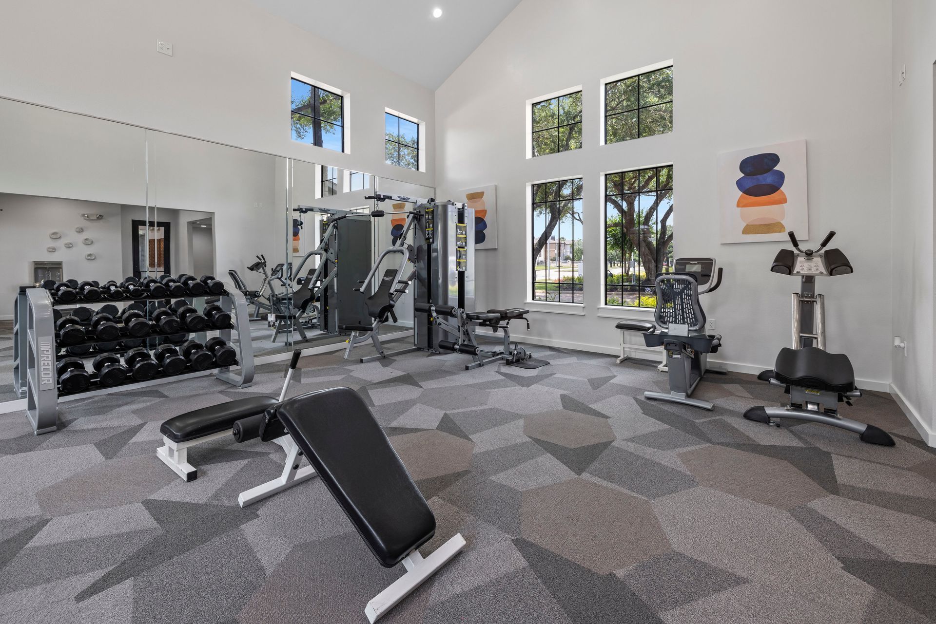 A large gym with a lot of equipment and a bench.