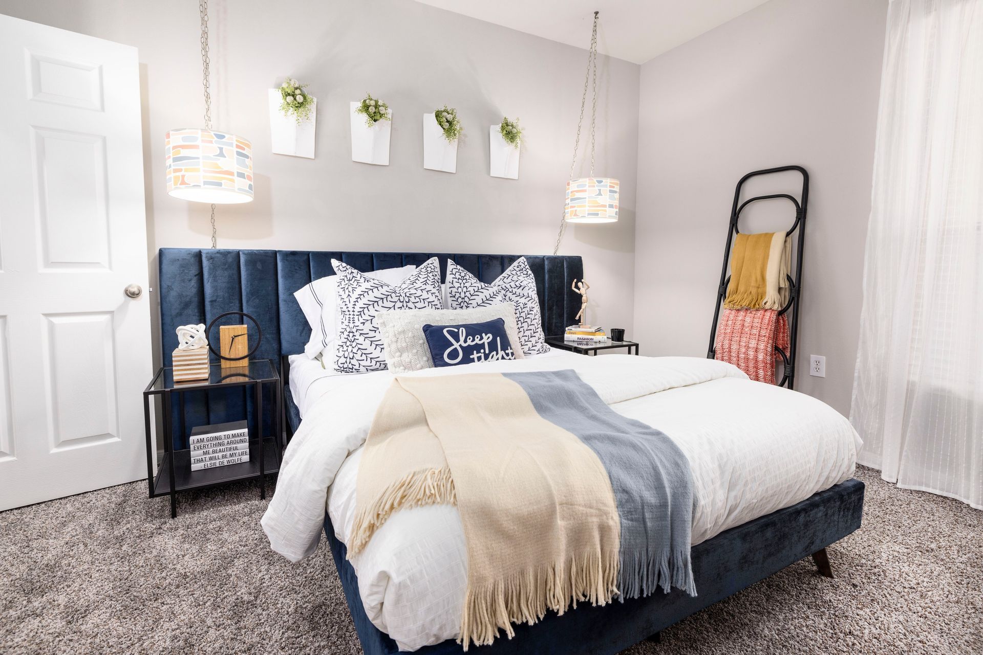 A bedroom with a bed , nightstands , lamps and a ladder.