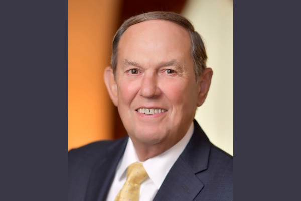 A man in a suit and tie is smiling for the camera