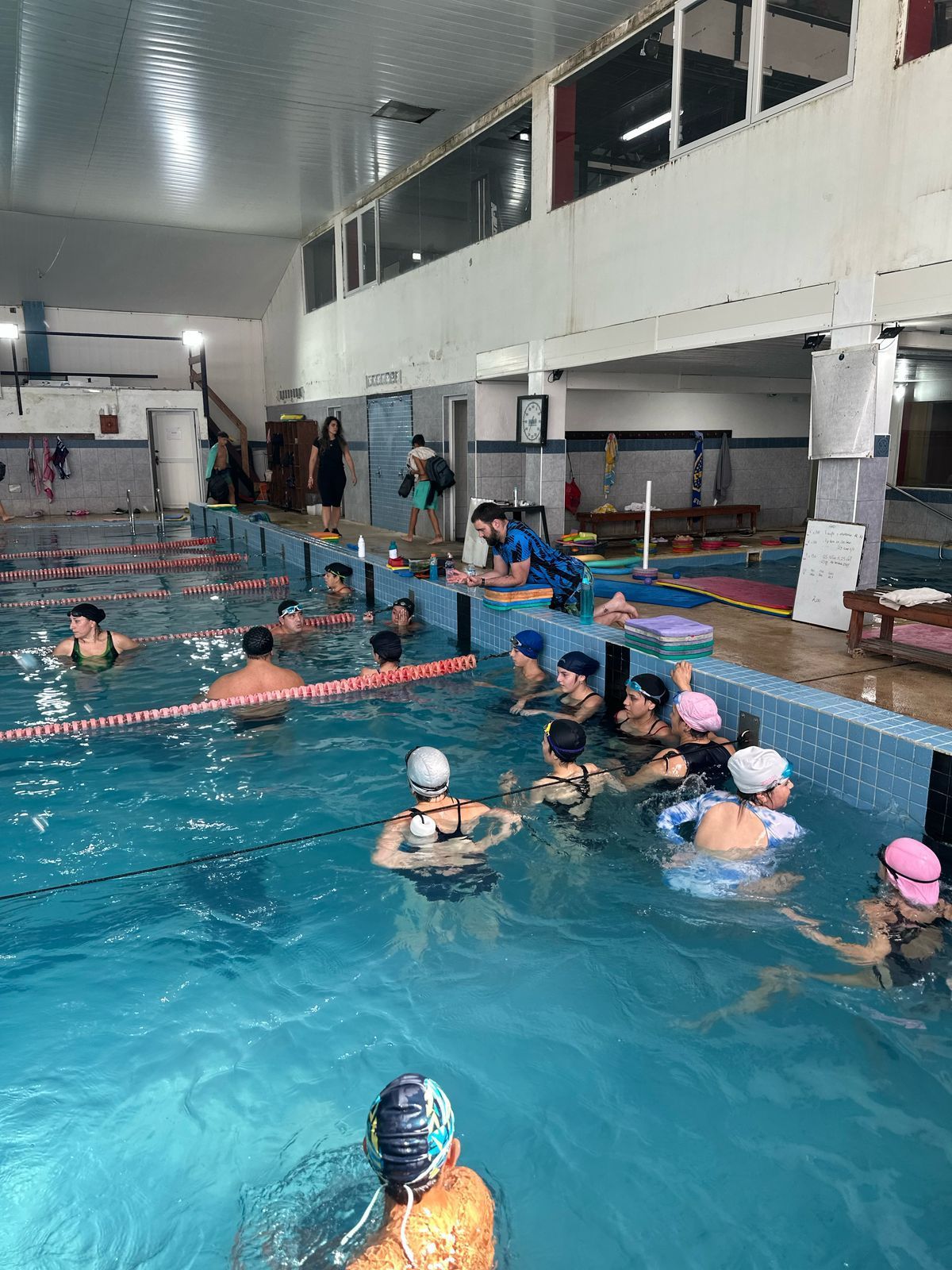 Un grupo de personas está nadando en una gran piscina cubierta.