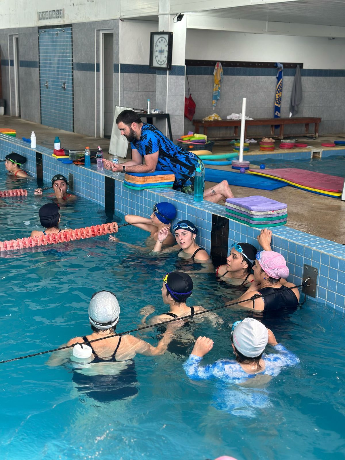 Un grupo de personas está nadando en una piscina.
