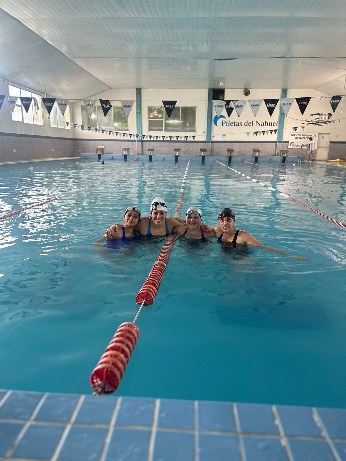 Un grupo de personas posa para una foto en una piscina.